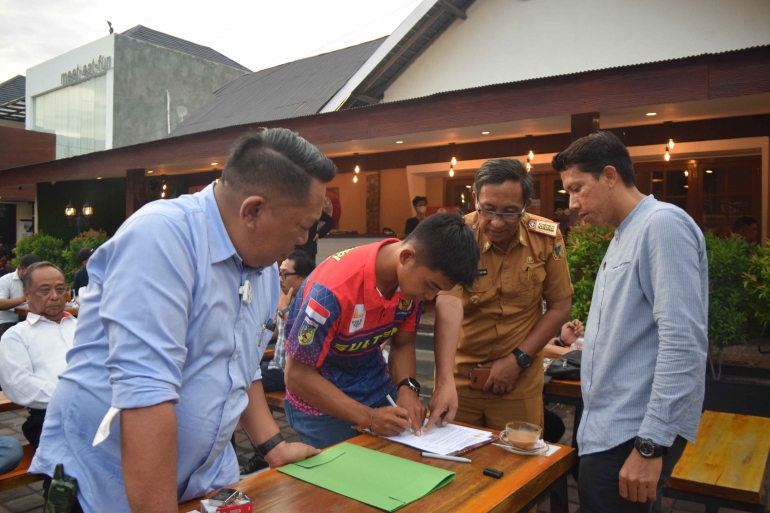 Rio Riski menandatangani berita acara penyerahan rumah. 