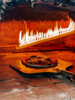 Proses pembuatan pizza dengan cara tradisional menggunakan tungku batu (sumber: dokumentasi At Last Social Space)