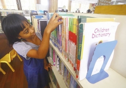 Seorang anak mencari buku di rak buku Children Library Perpustakaan Soeman HS (Evan Gunanzar/RIAU POS)