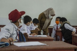Guru mengajarkan murid pada pelaksanaan pembelajaran tatap muka (PTM) 100 persen di SDN 065 Cihampelas (ANTARA FOTO/NOVRIAN ARBI)