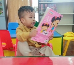 Anak mengekspresikan imajinasinya dari ilstrasi bukunya (Dokumentasi pribadi)