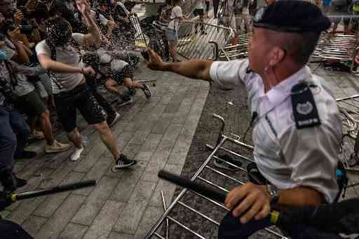 Seorang polisi menyemprotkan cairan lada kepada demonstran di Hong Kong pada bulan Juni 2019. | Sumber: Lam Yik Fei---The New York Times/Redux/via Time