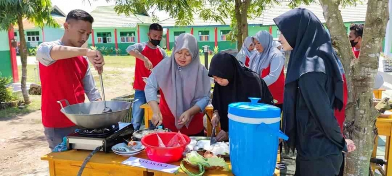 Guru Wali Kelas bersama siswa yang sementara meracik masakannya