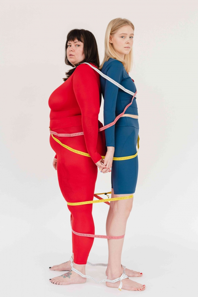Ilustrasi dua orang yang mengukur tubuhnya (Sumber : SHVETS Production www.pexels.com)