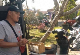 Di depan SAMSAT Malang seorang pemuda berjualan plastik pembungkus STNK | Dokumen pribadi 