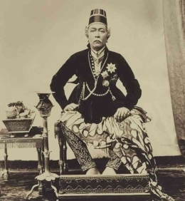 Sri Sultan Hamengkubuwono VII duduk di Dhampar Kencana (kemungkinan menggunakan agem-ageman dhalem bintang agung kumendor di dada sebelah kiri)