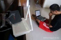 Pemuda mencari informasi di internet yang menggunakan jaringan IndiHome. Foto: Kontan