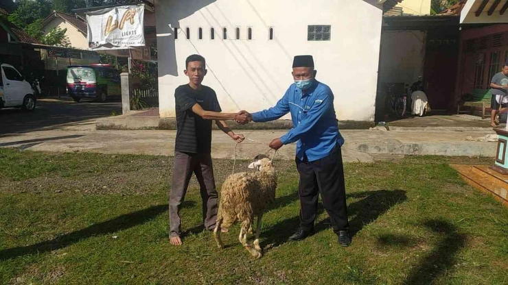 Toha (Kanan) saat membagikan kambing untuk warga dari RSI Banjarnegara./Dok RSI Banjarnegara
