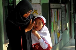 Seorang siswa kelas 1 menangis di hari pertama masuk sekolah (Sumber : regional.kompas.com)
