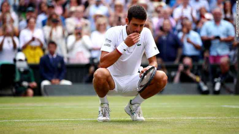 Novak Djokovic saat melakukan ritualnya mengunyah rumput Wimbledon (Gambar: edition.cnn.com)