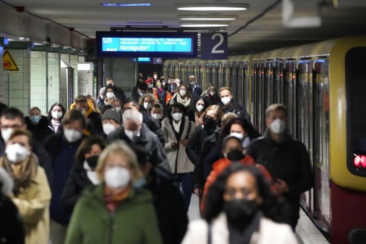 pengguna komuter mengenakan masker saat mereka tiba di stasiun transportasi umum Brandenburger Tor di Berlin, Jerman (AP PHOTO/MARKUS SCHREIBER)