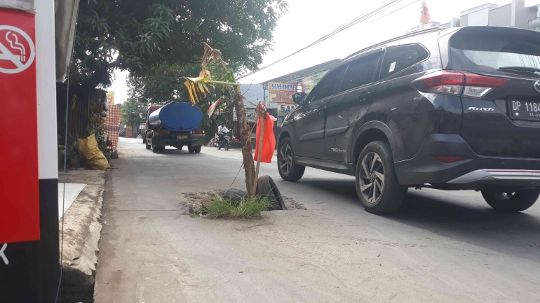 Jalan Berlubang di Poros Laikang Biringkanaya, Warga Tanam Pohon Pisang Sebagai Bentuk Protes (dok. Pribadi).