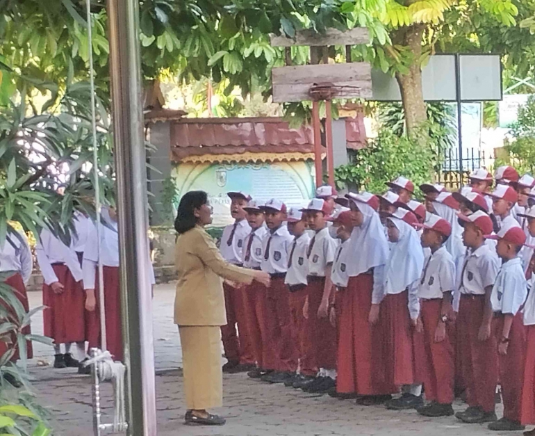 Momen mengumandangkan lagu Indonesia Raya dipandu oleh guru (Foto: Akbar Pitopang)