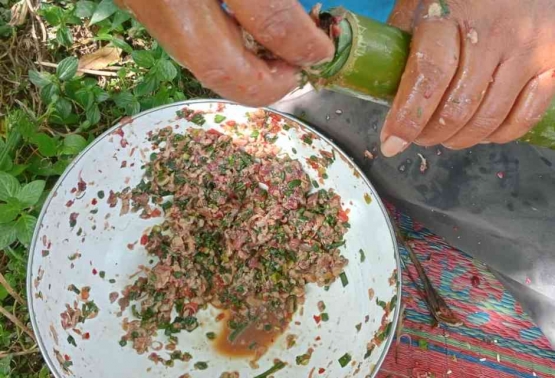 Memuat bahan isian daging cincang atau daging giling ke dalam ruas bambu untuk membuat kidu-kidu (Dok. Pribadi)