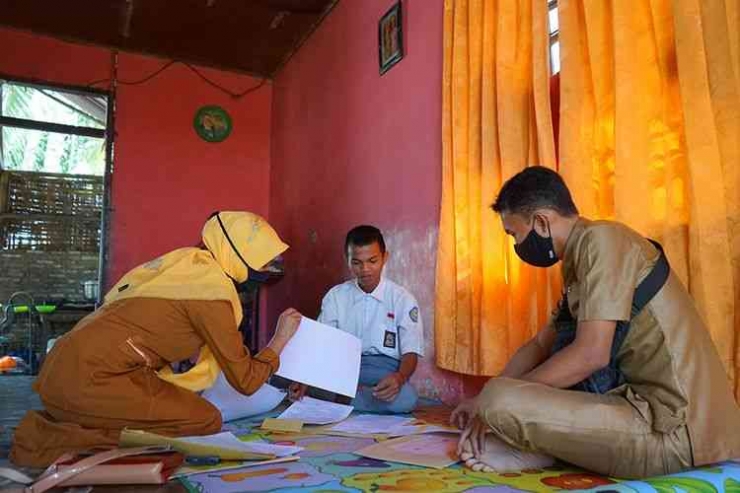 Dua guru SMA Negeri 1 Kabila mengawasi siswa yang melakukan ujian semester di rumah di Poowo, Kabupaten Bone Bolango (9/6/2020(ANTARA FOTO/ADIWINATA SOLIHIN)