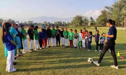 Pelatih sepakbola perempuan Nadiya Nighat (kanan) sedang melatih anak-anak. | Sumber: The Guardian