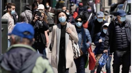 Pejalan kaki yang memakai masker di bahu jalan. https://www.ny1.com/nyc/