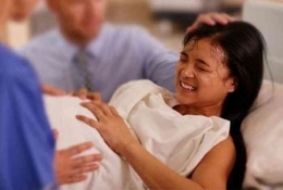 Ilustrasi wanita sedang melahirkan dengan bantuan tenaga medis (sumber: bangsaonline.com)
