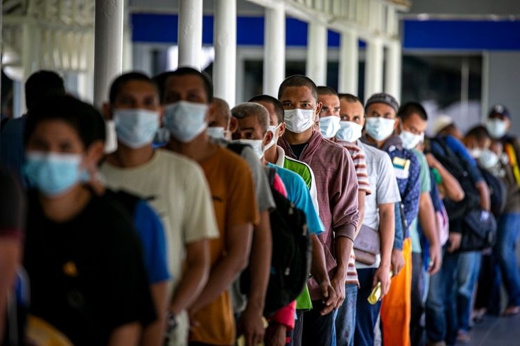 Sejumlah pekerja migran Indonesia (PMI) yang baru tiba antre untuk pengecekan suhu tubuh di Pelabuhan Internasional Batam Centre, Batam, Kepulauan Riau, Kamis (21/5/2020).| ANTARA FOTO/M N Kanwa/nz