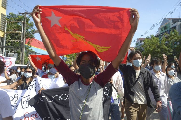 Pengunjuk rasa anti kudeta mengibarkan bendera partai Liga Nasional untuk Demokrasi (NLD) selama demonstrasi di Yangon, Myanmar, Jumat (14/5/2021).(Foto: AP via kompas.com) 