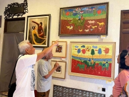 Seorang pengunjung mengamati lukisan 