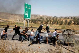 Demonstran Palestina yang terluka memberi isyarat saat dia dievakuasi selama bentrokan dengan pasukan Israel, 14 Mei 2021. REUTERS/Raneen Sawafta