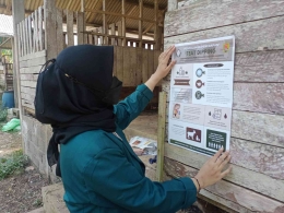 Pemasangan poster mengenai penerapan teat dipping di salah satu kandang milik peternak sebagai output dari kegiatan penyuluhan.