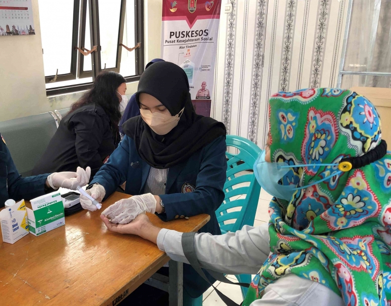 Mahasiswa KKN Tim II UNDIP 2022 melakukan pemeriksaan gula darah di Kelurahan Cabean. Foto: Dok. Pribadi 