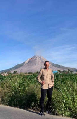 Penulis dengan latar belakang Gunung Sinabung saat perjalanan menuju Kebun Kurma (dokpri)