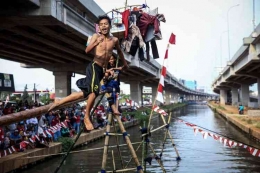 warga mengikuti lomba panjat pinang, pukul bantal dan makan donat HUT RI di saluran Kalimalang Jakarta timur (Kompas.com/GARRY LOTULUNG)