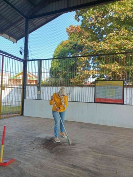 Seorang  pegawai Rupbasan Palembang membersihkan lantai area gudang terbuka (Dokpri)