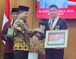 Bupati Sambas H. Satono, S.Sos, I., M.H., menyerahkan anugerah kehormatan Putra Madya Sambas kepada Ketua Umum Fogoromas Jakarta Budianto, S.E., Rabu (17/8/2022)/Foto:dok.Fogoromas