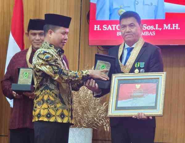 Bupati Sambas H. Satono, S.Sos, I., M.H., menyerahkan anugerah kehormatan Putra Madya Sambas kepada Ketua Umum Fogoromas Jakarta Budianto, S.E., Rabu (17/8/2022)/Foto:dok.Fogoromas
