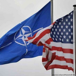 Potret bendera NATO berdampingan dengan bendera Amerika (sumber: dw.com)