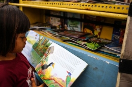 Anak-anak membaca buku di bemo perpustakaan di Jalan Karet Pasar Baru Barat II, Tanah Abang, Jalarta Pusat, Jumat (7/12/2018).(KOMPAS.com/GARRY LOTULUNG) 