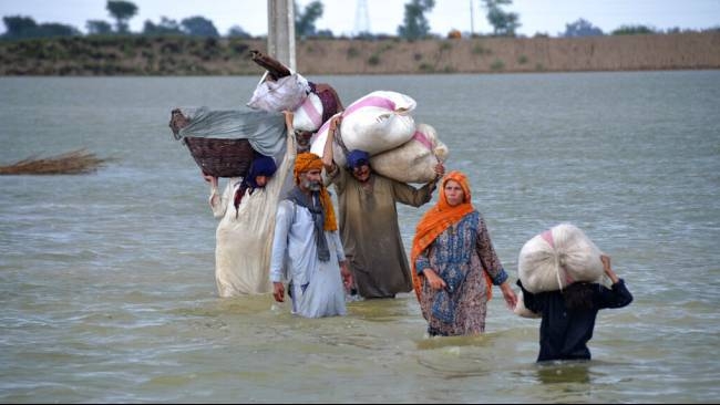 Satu keluarga berjalan menerobos banjir yang terjadi setelah hujan deras mengguyur Jaffarabad, sebuah distrik di Provinsi Baluchistan, Pakistan pada Rabu, 24 Agustus 2022.| Sumber: AP Photo/Zahid Hussain via Kompas TV
