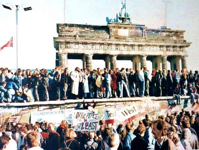 Warga Kota Berlin Jerman, bersorak-sorai di atas Tembok berlin ketika hendak dirubuhkan | Sumber Gambar: History.com