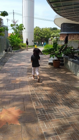 Seorang gadis kecil berlari tergesa ditunggui ayahnya karena terpesona pada tempat bermain (dokpri by IYeeS) 