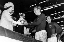 Ratu Elizabeth II menyerahkan trofi Piala Dunia 1966 kepada kapten Inggris Bobby Moore. foto Kompas/AFP