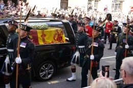 Mobil jenazah perlahan melintasi Royal Mile, diikuti oleh anak-anak Ratu yang berbaris mengikuti (Foto: Andrew Milligan/PA Photos/ABACAPRESS.COM)