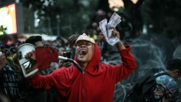 Seorang demonstran memakai kostum ala film Money Heist. (Jonas/Mahasiswa)