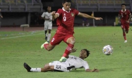Pemain Timnas U20 Indonesia (kaos merah) ketika melewati pemain Timor-Leste (foto: Antara)