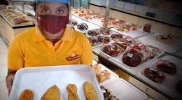Seorang karyawan Royal Bakery tengah memperlihatkan aneka risoles yang dijual. / Foto: Effendy Wongso