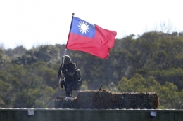 Foto pada 19 Januari 2021 memperlihatkan seorang tentara memegang bendera Taiwan dalam latihan militer untuk menangkal serangan China, di Hsinchu, utara Taiwan. (AP PHOTO/CHIANG YING-YING via koamps.com) 