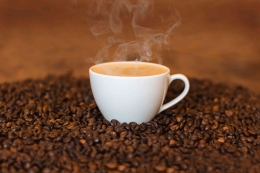 Secangkir kopi di atas biji kopi yang sudah diroastery. Foto: hipwee.com