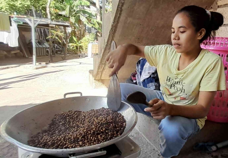 Ponakan sedang menyangrai kopi secara tradisional. | Dokumentasi pribadi