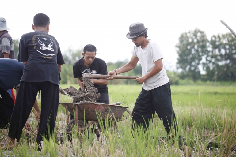 Sugianto (tengah) bersama Rudi (kanan) sedang memindahkan tanah ke gerobak dorong. Foto: Irvan Prasetya