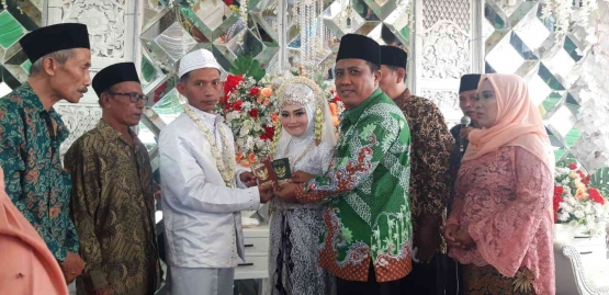 Penyerahan buku nikah salah satu bagian penting dalam akad nikah (Sumber gambar: Hamim Thohari Majdi)