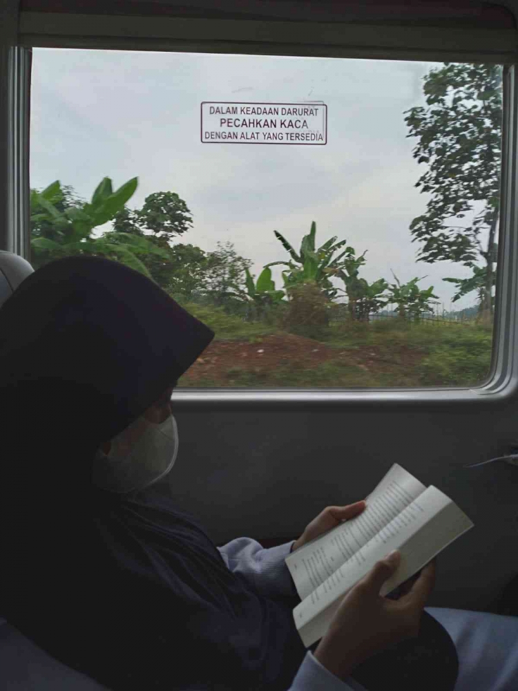 Teteh menikmati perjalanan kereta api dengan membaca buku. Dokumen pribadi