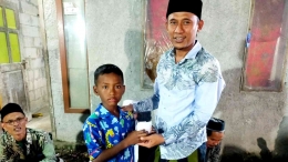 Kepala Desa Ranjeng Kecamatan Ciruas, Sapta Mulyana beri santunan kepada seorang anak (dokpri)